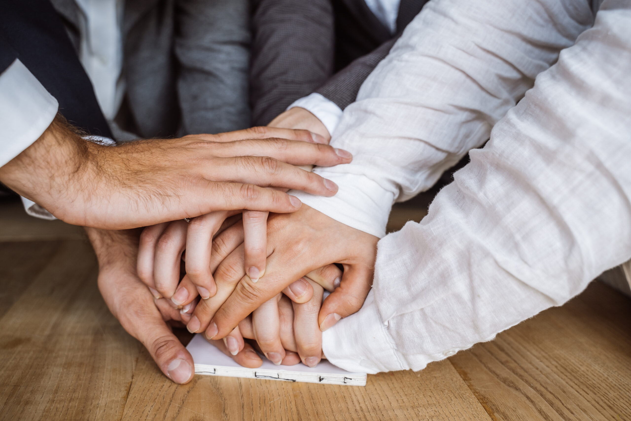 United hands of business team on workspace background. close view